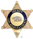 Six-point gold star badge with a circular center that reads SHERIFF LOS ANGELES COUNTY and includes an image of a bear in the middle.